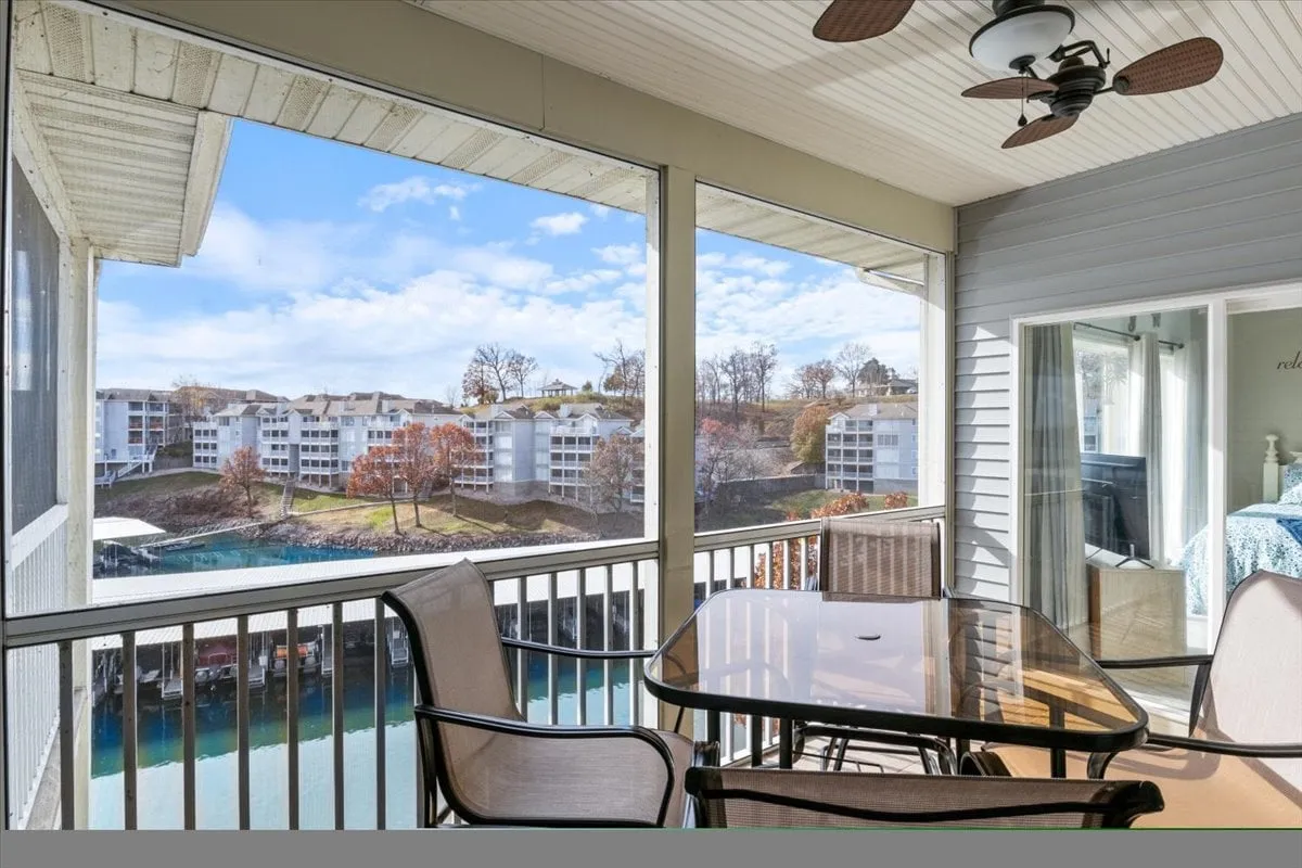 This image features a tranquil outdoor seating area overlooking the lake, complete with comfortable chairs and a ceiling fan. The space is perfectly positioned to showcase the breathtaking water views and is ideal for group gatherings, morning coffee, or relaxed evening chats as the sun sets.