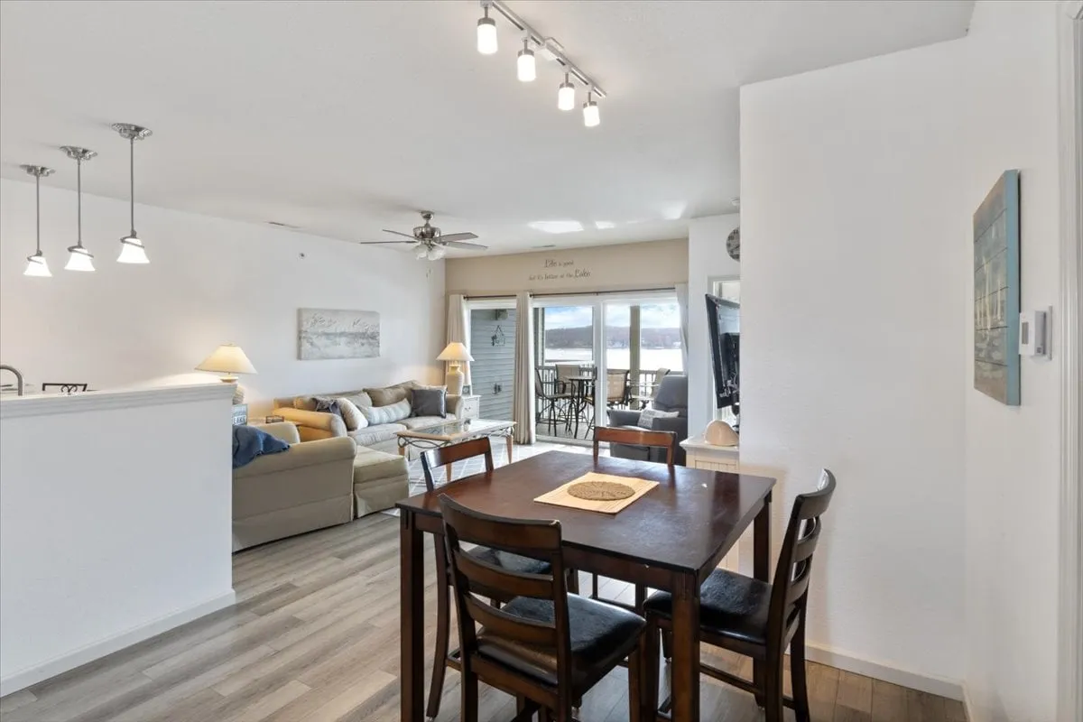 A warmly lit dining and living area with a large dining table, cozy sofa, and expansive windows that reveal a beautiful view beyond. The setup is inviting and ideal for both everyday meals and special celebrations.