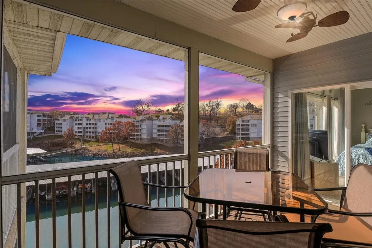 An inviting exterior scene showing an outdoor dining table set on a deck, overlooking a picturesque sunset on the lake. The warm glow and surrounding landscape evoke feelings of relaxation and social gatherings after an active day.